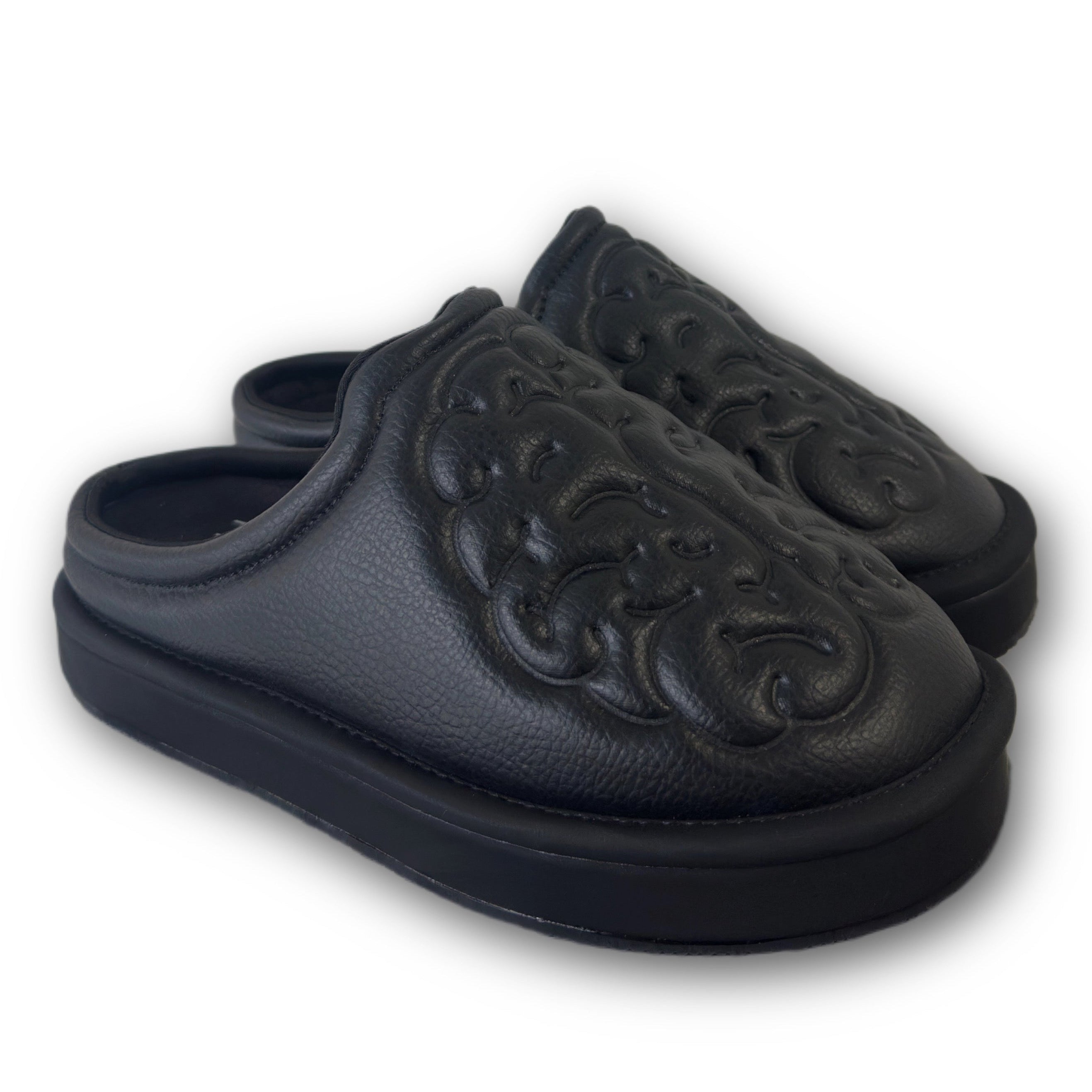 Black leather shoes with brain embossed design on a white background angled view