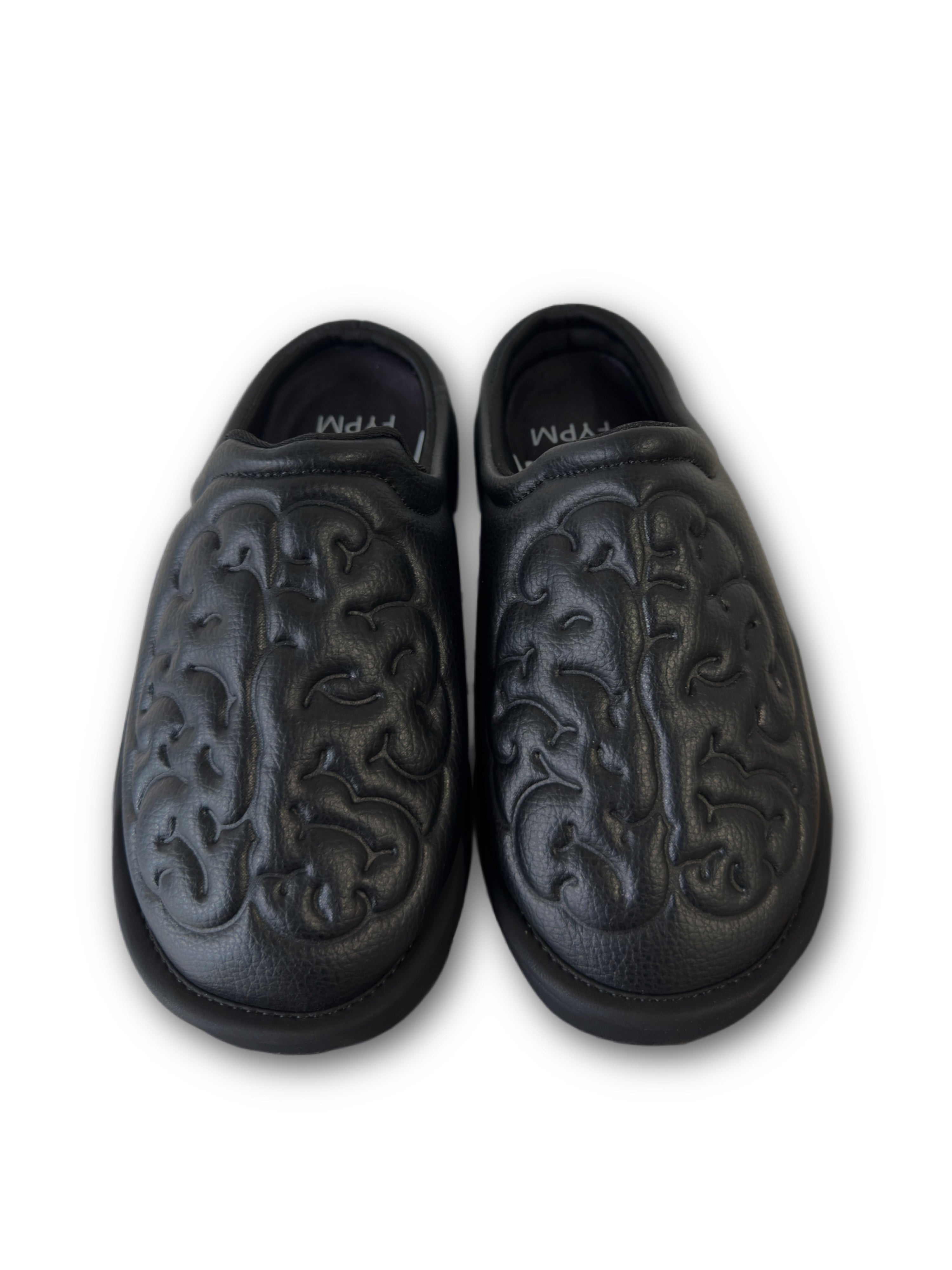 Black leather shoes with brain embossed design on a white background top view